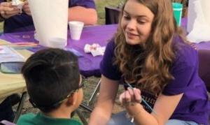 CSD student painting a kid's face at an HSU event.